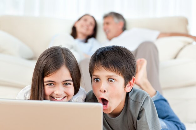 Lovely children watching a movie on their laptop at home