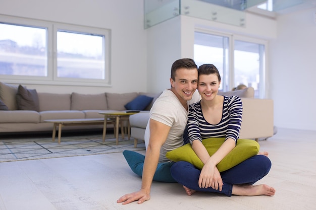 Foto bella coppia che si gode il tempo libero seduto sul pavimento nel salotto di casa