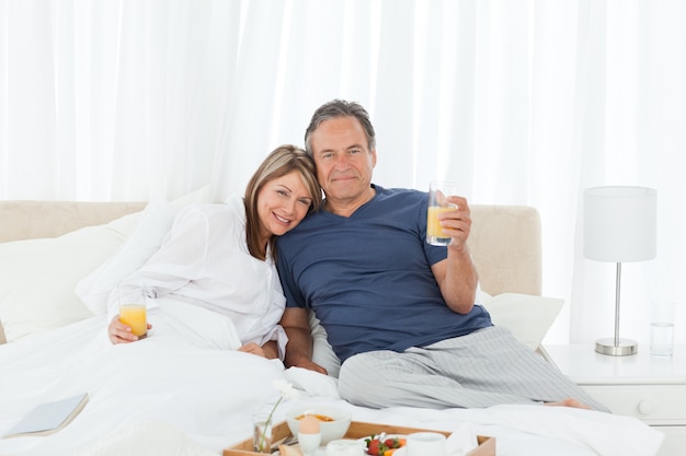 Lovely couple having breakfast in their bed 