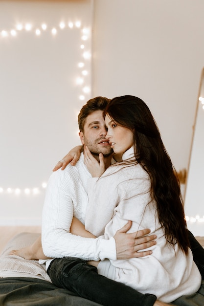 Lovely couple hugging on their bed at home