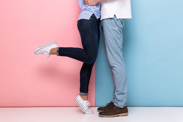 Lovely couple kissing and hugging together, isolated over colorful wall