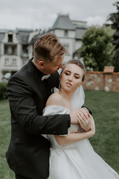 The lovely couple in love embracing and standing in the park