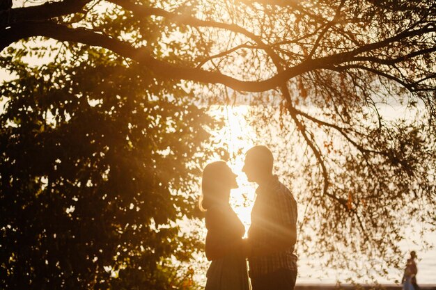 Lovely couple relax in park together with sunlight silhouette