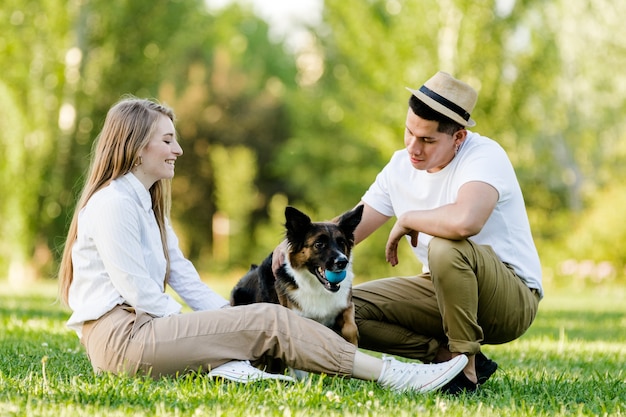 Lovely couple with their dog having fun in the park