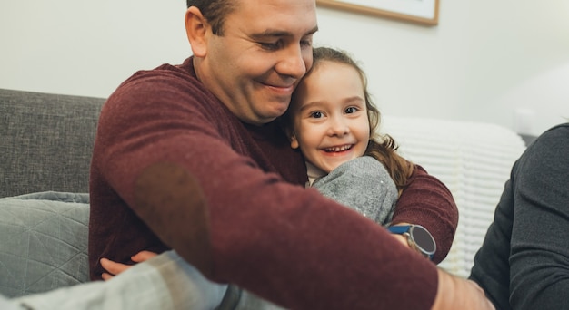 Photo lovely dad who is telling a story for his daughter making her laugh and ready for sleep