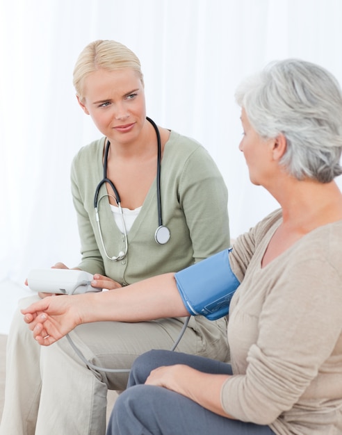 Lovely doctor taking the blood pressure of her patient