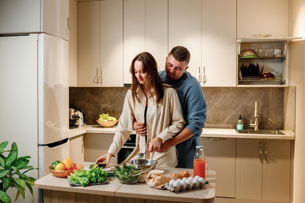 Lovely family couple preparing vegetable vegan salad together in kitchen Healthy food and diet concept lifestyle Cook at home