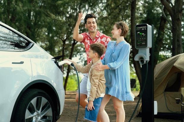 Photo lovely family recharge ev car with ev charging station in campsite perpetual