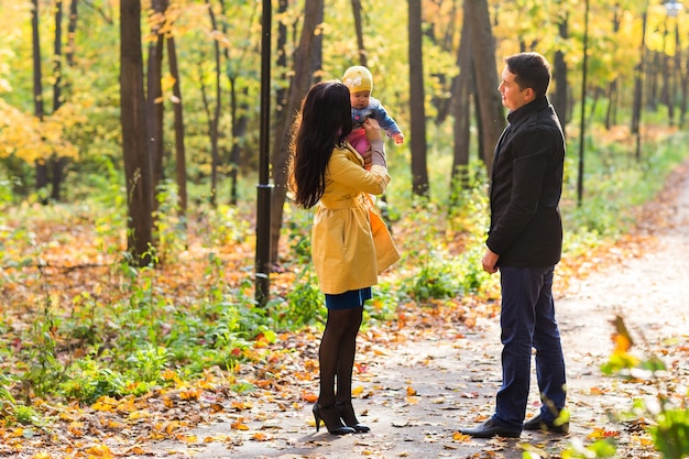 가을 숲에서 산책하는 사랑스러운 가족. 건강한 생활.