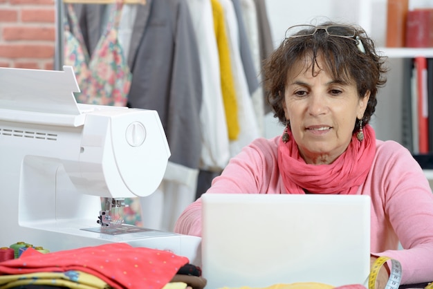 Stilista adorabile che lavora al computer portatile