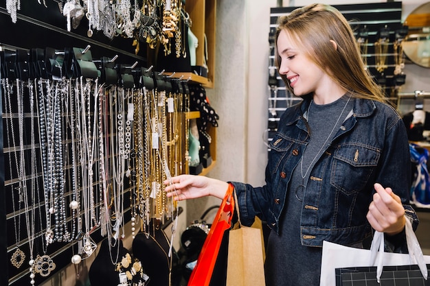 Foto ragazza bella esplorare gli accessori in negozio