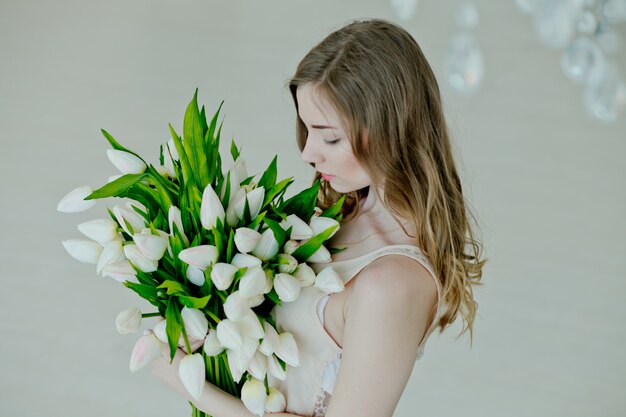 素敵な女の子は花の花束を保持します。