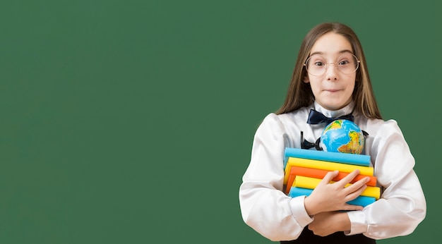 Lovely girl holding book pile copy space