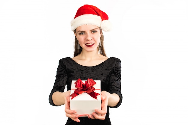 Милая девушка держит подарок и улыбка на камеру на белом изолированные