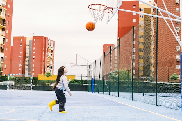 Photo lovely girl playing basketball