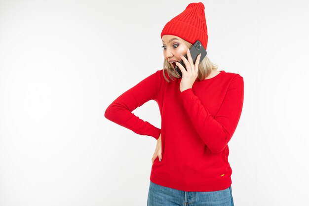 Lovely girl in red chats on the phone with copy space
