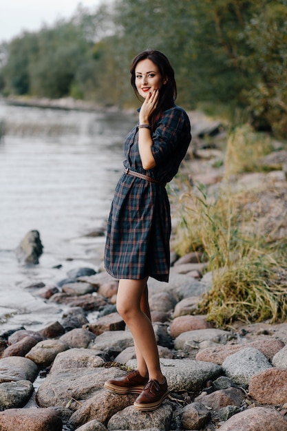 Photo lovely girl stands on the beach and smiles