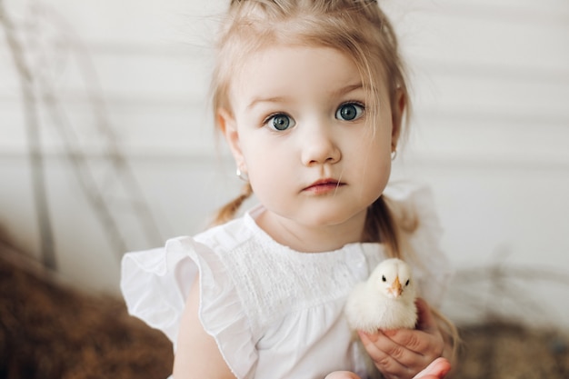 Bella ragazza con grandi occhi belli mantenendo piccolo pulcino