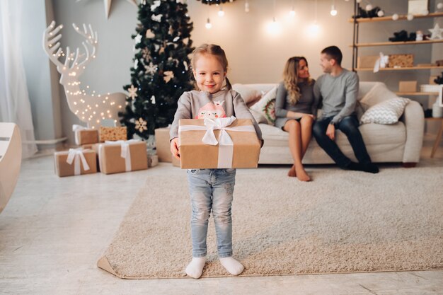 Lovely girl with present against her parents.