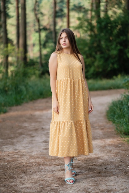 Lovely girl in yellow summer dress outdoors