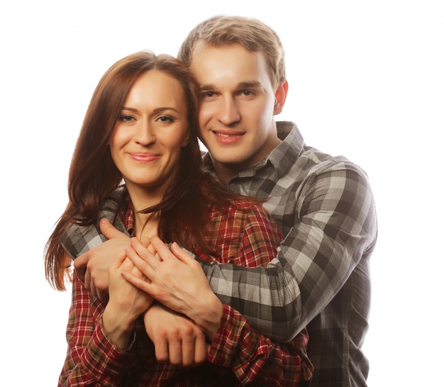 Lovely happy couple hugging over grey