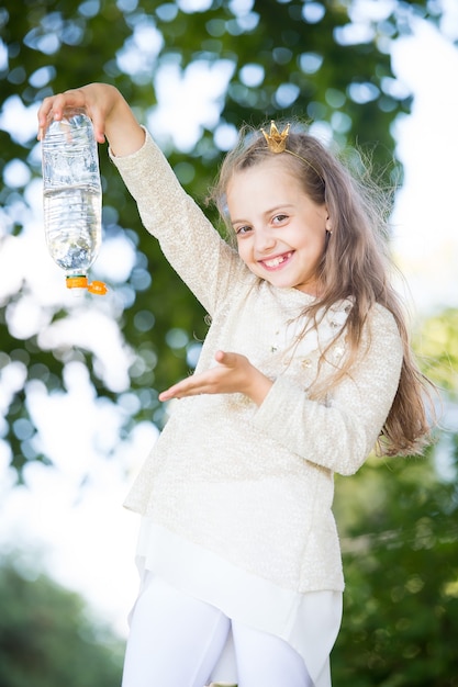 Lovely happy little princess girl with water on natural background