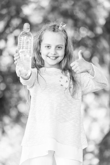 자연 배경에서 예 제스처를 보여주는 물과 사랑스러운 행복한 작은 공주 소녀