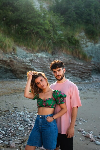 Lovely heterosexual couple on a rocky beach embracing and kissing at the Basque Country.