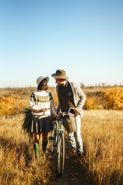 Lovely hipster couple with bike Couple wearing beautiful hats and sweaters Lifestyle