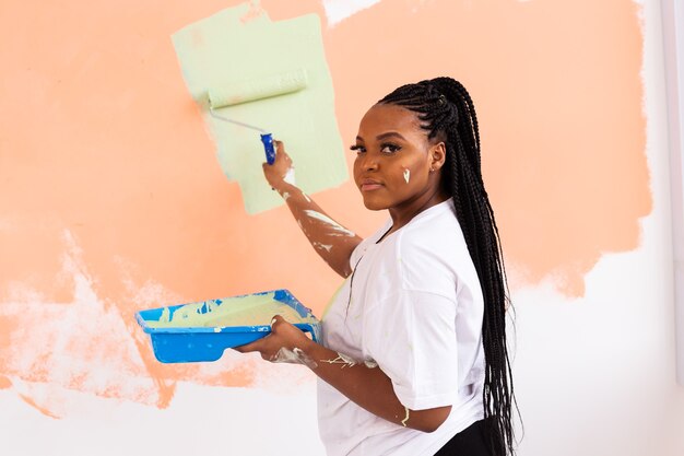 Lovely housewife painting wall