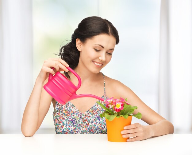 Adorabile casalinga con fiori in vaso e annaffiatoio