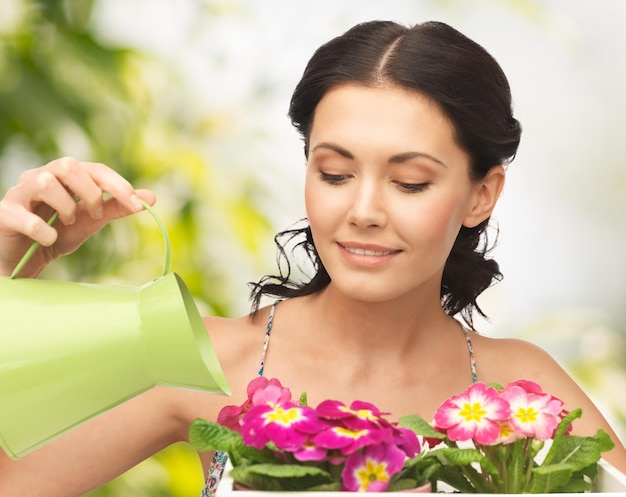 lovely housewife with flower in pot and watering can