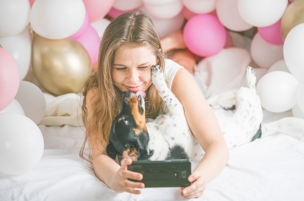 Lovely lady in pajama making selfie in her bedroom using phone