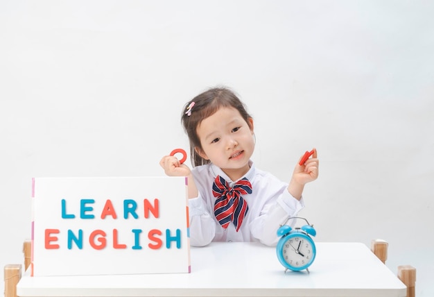 Photo the lovely little girl is learning letters