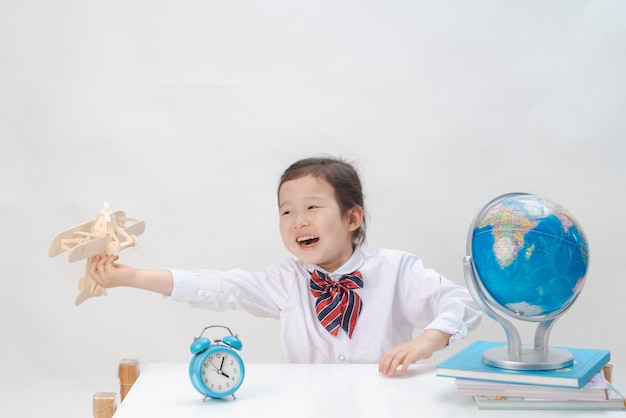 L'adorabile bambina sta imparando la mappa con un piccolo aereo