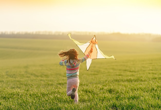 Lovely little girl running with kite