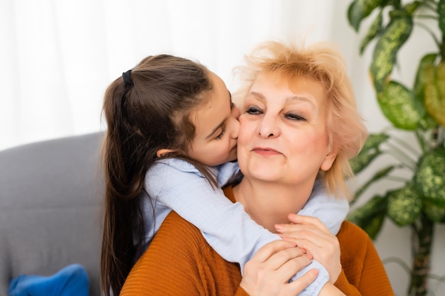 Lovely little girl with her grandmother looking at the camera.