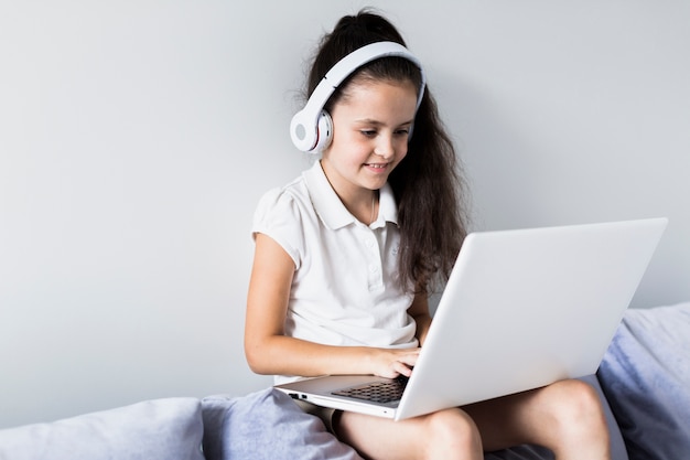 Photo lovely little girls using her laptop