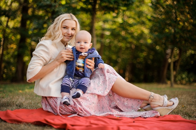 Madre adorabile con un figlio neonato sul picnic