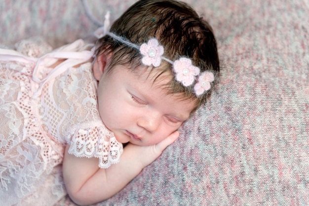 Lovely newborn girl in dress sleeping