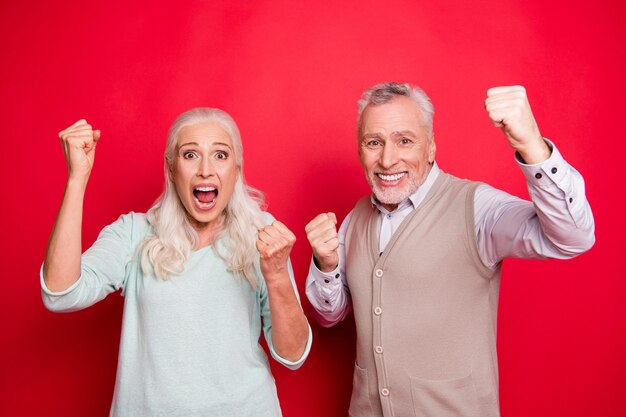 Lovely older couple posing together against the red wall