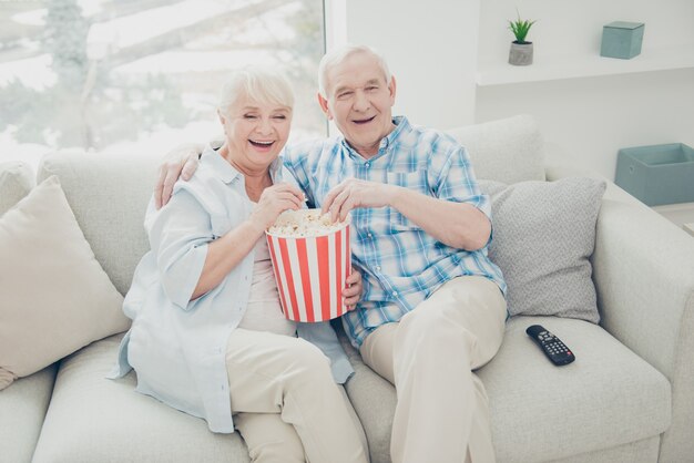 Bella coppia di anziani in posa insieme sul divano