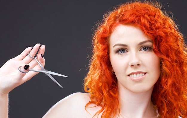 lovely redhead with scissors over grey