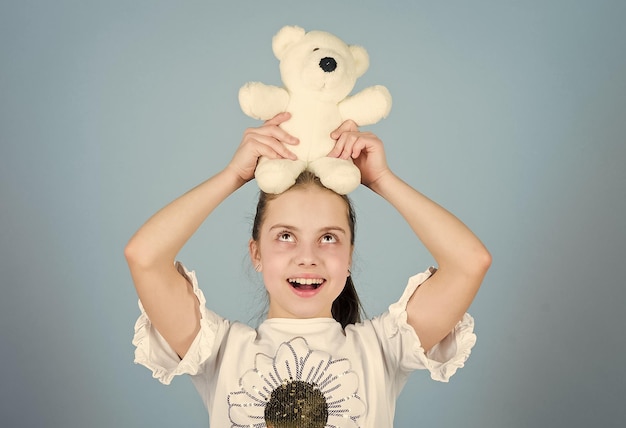 Lovely small girl smiling happy face with favorite toy Best friends Imaginary friend Little girl play with soft toy teddy bear Happy childhood Child care Sweet childhood Childhood concept