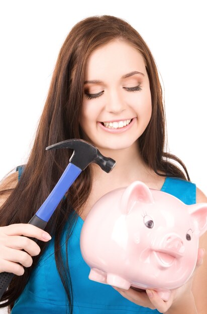 lovely teenage girl with piggy bank and hammer