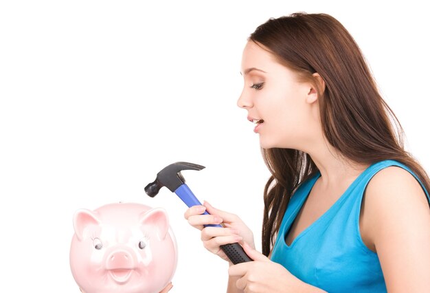 lovely teenage girl with piggy bank and hammer