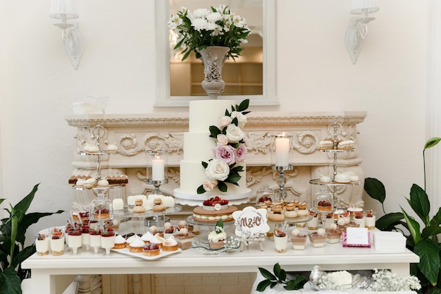 Una bella torta nuziale in piedi tra il candy bar. dolce tavola. tavola del banchetto. cibo per le vacanze. dolce tavola festiva.