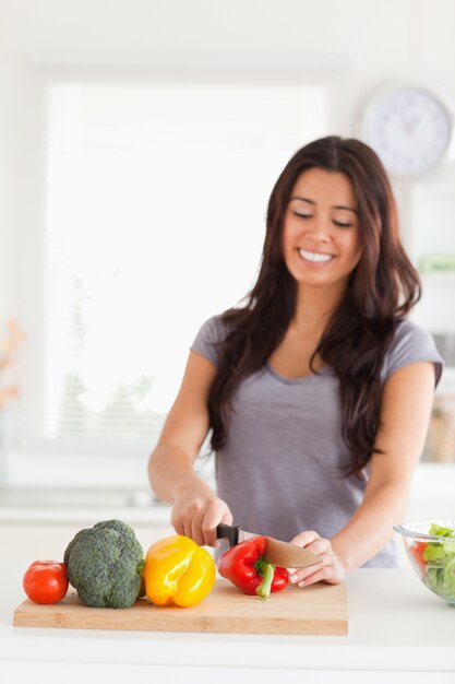 Lovely woman cooking vegetables while standing