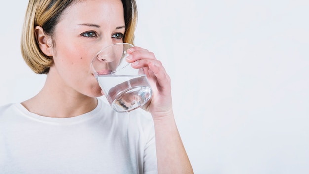 Lovely woman drinking water on white background