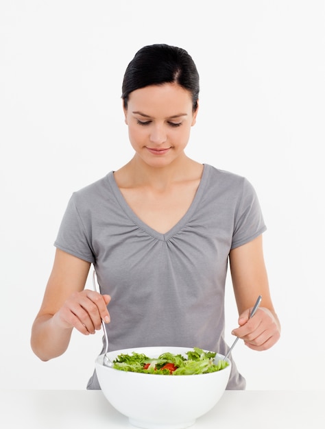 Lovely woman mixing a salad standing in the kitchen 